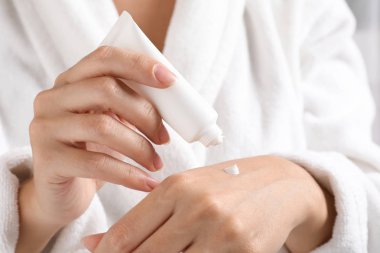 Nemlendirici El kremi, uygulama bornoz closeup kadında. Kış Cilt Bakımı kozmetik