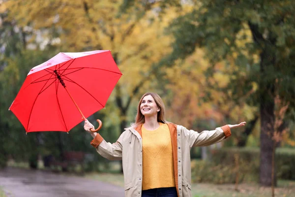 雨の日に秋の公園で傘を持つ女性 — ストック写真