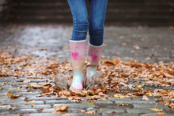 ゴムを身に着けている女性の足に焦点を当てるの雨の後水たまりの中で水しぶきブーツします 秋の散歩 — ストック写真
