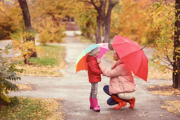 母と娘は傘を雨の日に秋の公園で散歩 — ストック写真