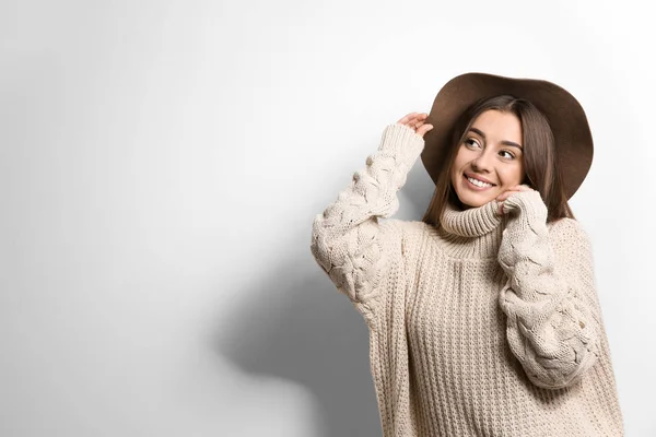 白い背景の上の帽子と暖かいセーターで美しい若い女性 テキストのためのスペース — ストック写真