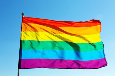 Gökkuşağı Lgbt bayrağı mavi gökyüzü arka planda çırpınan. Eşcinsel hakları hareketi