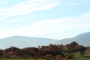 Dağ yamaçlarında mavi gökyüzü olan güzel bir manzara.