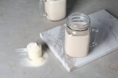 Mason kavanoza protein içeceği ve kaşık toz masada