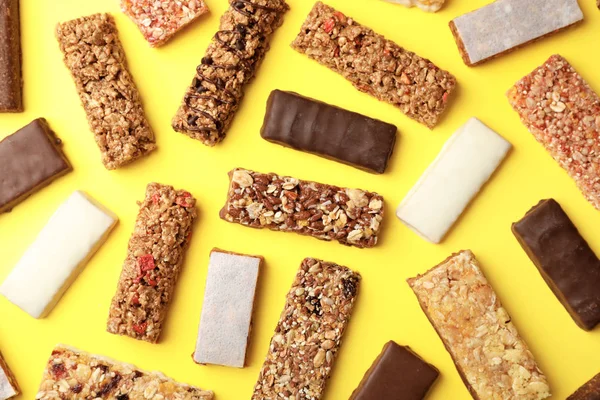Flat lay composition with protein bars on color background