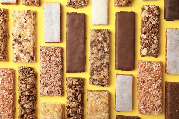 Flat lay composition with protein bars on color background