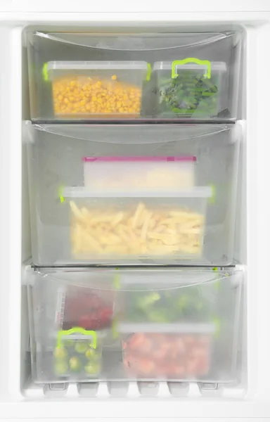 Containers with frozen vegetables in refrigerator, closeup