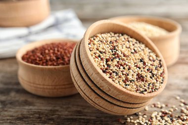 Ahşap masa üzerinde karışık quinoa tohumları ile kase