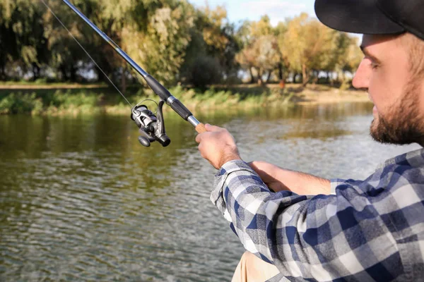 Man with rod fishing at riverside. Recreational activity