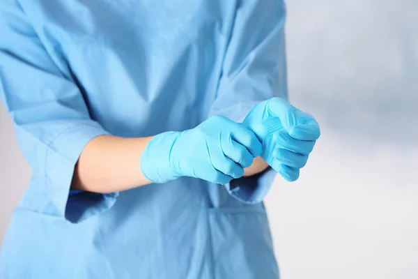 Arzt Zieht Medizinische Handschuhe Auf Farbigem Hintergrund Aus — Stockfoto