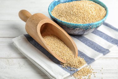 Kase ve ahşap masa üzerinde beyaz quinoa ile kepçe