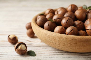 Plaka ile organik Macadamia fındık ve ahşap arka plan üzerinde metin için yer