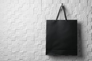 Kağıt alışveriş çantası ile kurdele beyaz duvarda asılı işler. Mockup tasarım için