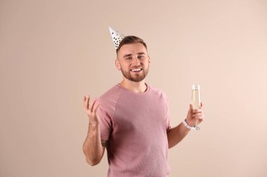 Parti kap ve şampanya renk arka plan üzerinde cam ile mutlu bir adam portresi