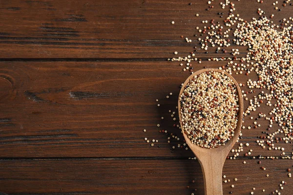Karışık quinoa tohumları ve uzay kaşıkla ahşap arka plan, üstten görünüm üzerinde metin için