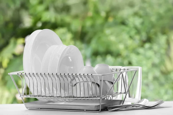 Set of clean dishware on table against blurred background