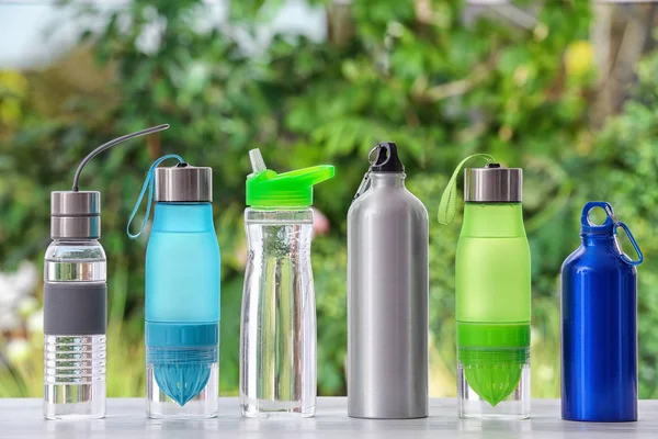 Sports water bottles on table against blurred background