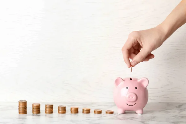 Mujer Poniendo Moneda Alcancía Contra Fondo Claro Espacio Para Texto — Foto de Stock