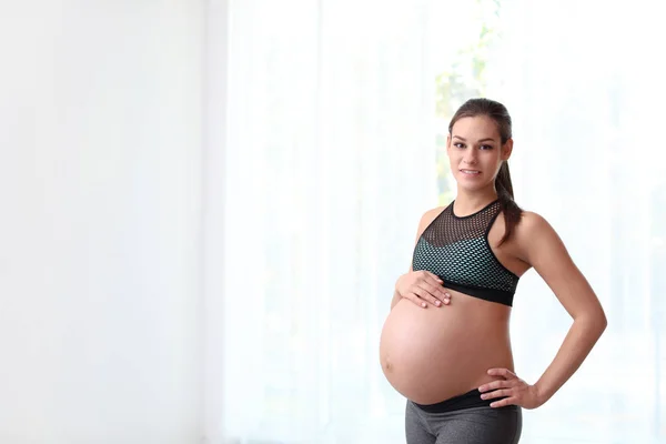 年轻的孕妇穿着健身服在家 文本的空间 — 图库照片