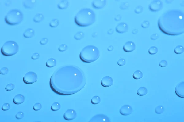 Pure water drops on color background, closeup