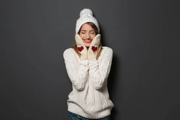 暖かいセーターと帽子とミトン暗い背景に美しい若い女性 — ストック写真