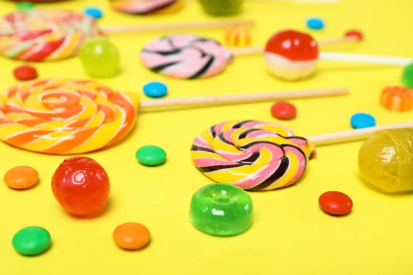 Many different tasty candies on color background, closeup
