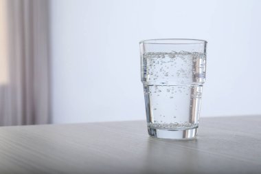 Bardak su tablo arka plan bulanık karşı. Metin için yer