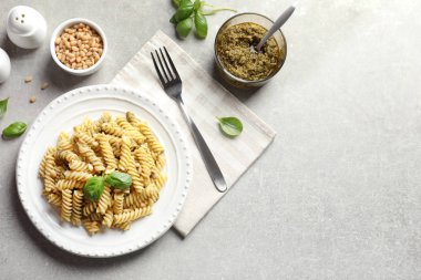 Plaka ile düz yatıyordu bileşimi lezzetli fesleğen pesto makarna ve metin gri tablo için yer