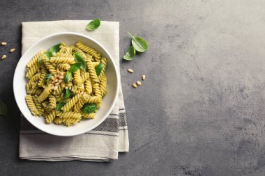 Tabak lezzetli fesleğen pesto makarna gri tablo, üstten görünüm. Metin için yer