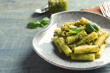 Plaka ile lezzetli fesleğen pesto makarna üzerine ahşap masa
