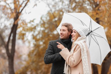 Sonbahar gününde Park şemsiye ile genç romantik çift
