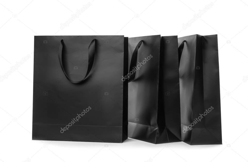 Paper shopping bags with ribbon handles on white background. Mockup for design