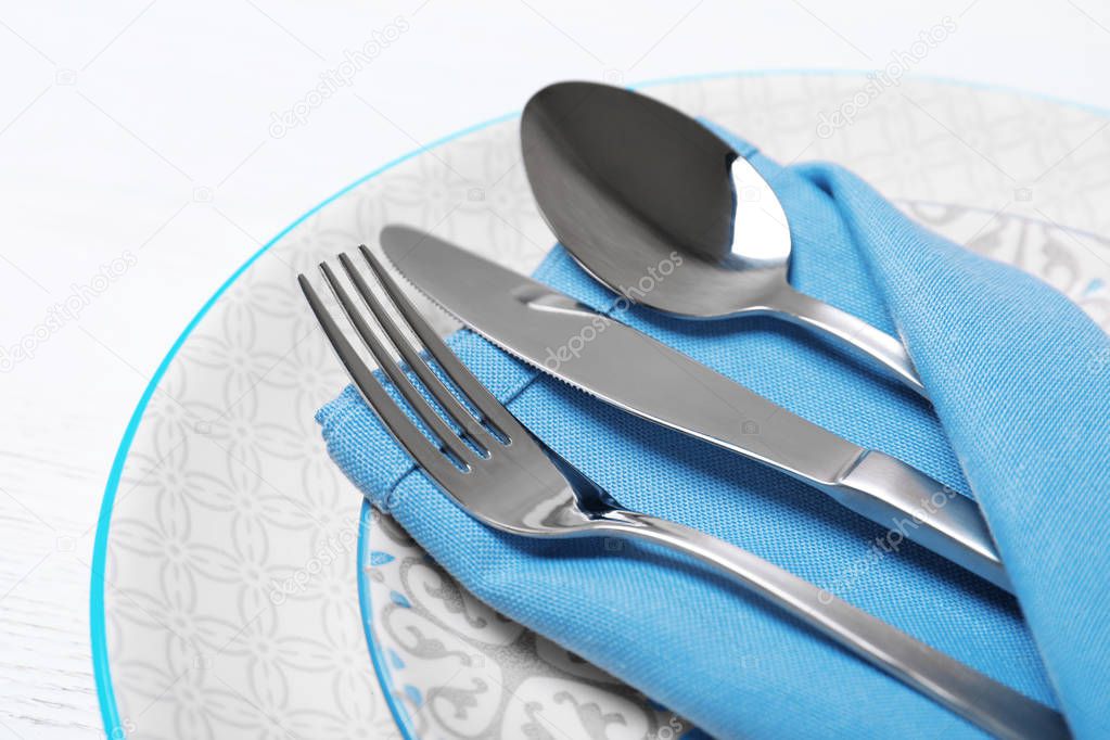 Plates, cutlery and napkin on white background, closeup. Festive table setting