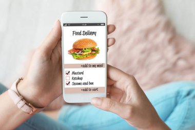 Smartphone-e doğru sipariş gıda teslim evde kullanan kadın
