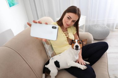 Güzel kadın evde kanepede onun köpeği ile selfie alarak