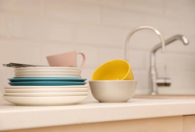 Temiz dishware ve evye yakınındaki sayaçta çatal bıçak takımı