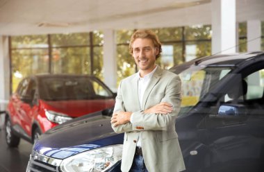 Genç adamın yanında yeni arabanın içinde modern araba satışı