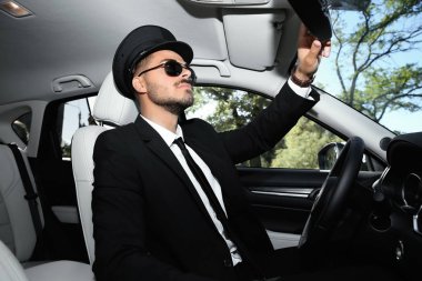 Genç yakışıklı sürücü iç lüks araba aynada ayarlama