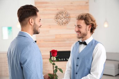 Evde çiçek ile mutlu yeni evli gay çift