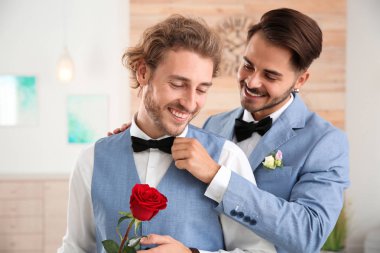 Evde çiçek ile mutlu yeni evli gay çift