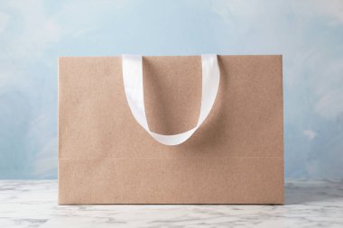 Kağıt alışveriş çantası kurdele ile renk arka plan karşı masada işler. Mockup tasarım için