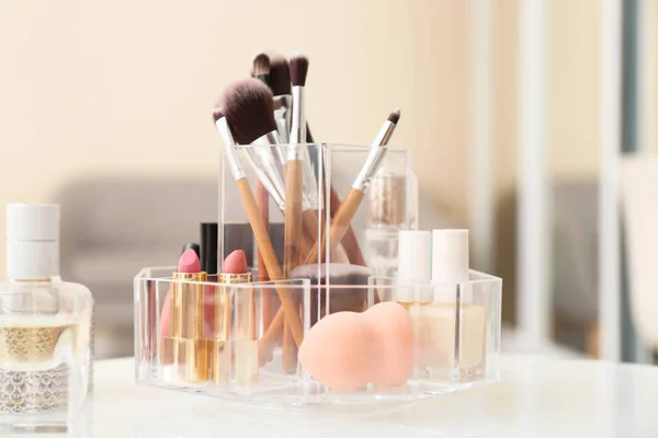Organizer with cosmetic products for makeup on table indoors