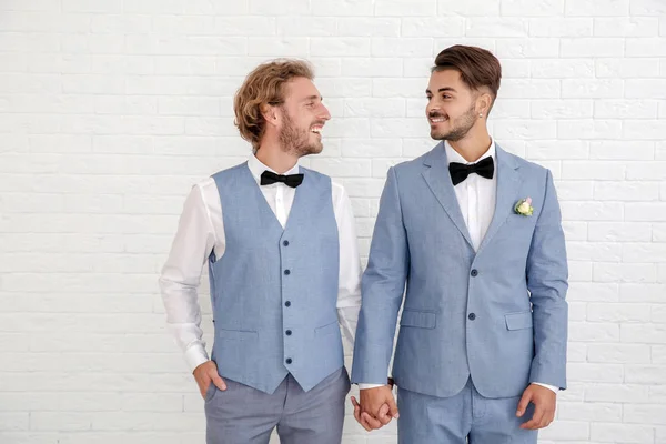 Lycklig Nygift Homosexuella Par Kostymer Mot Vit Vägg — Stockfoto