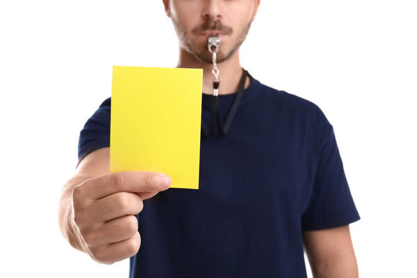 Футбольный судья держит желтую карточку на белом фоне, крупный план
