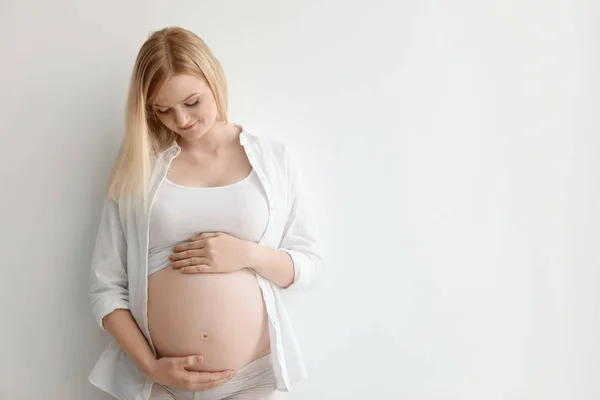 明るい背景に美しい妊娠中の女性の肖像画 テキストのためのスペース — ストック写真