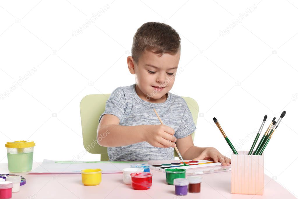 Cute child painting picture at table on white background