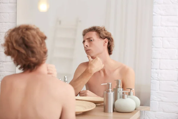 Νεαρός Άνδρας Κοιτάζοντας Στον Καθρέφτη Μετά Ξύρισμα Στο Σπίτι — Φωτογραφία Αρχείου
