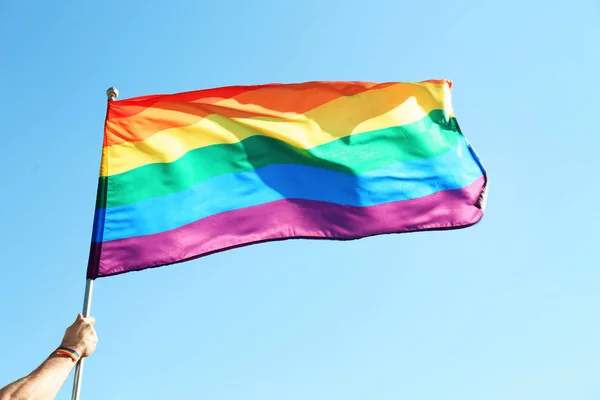 Gökkuşağı Lgbt Bayrağı Mavi Gökyüzü Arka Plan Üzerinde Tutan Eşcinsel — Stok fotoğraf