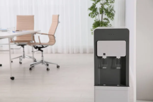 Modern water cooler in stylish office interior. Space for text