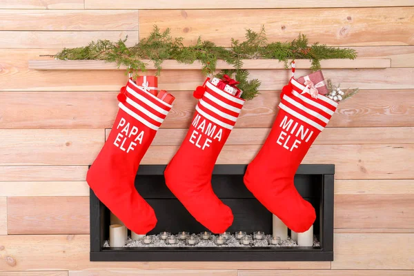 挂在木墙上的圣诞长袜 靠近装饰壁炉 节日内部 — 图库照片